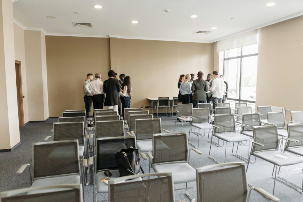 A diverse group of professionals having a discussion in an empty conference room.